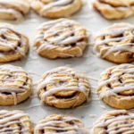 freshly baked cinnamon roll cookies on a white plate in a bright modern kitchen