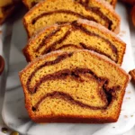 fresh cinnamon swirl pumpkin bread minis on marble counter with soft daylight