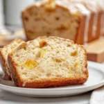 slice of heavenly peach bread with vanilla glaze on white plate in modern kitchen