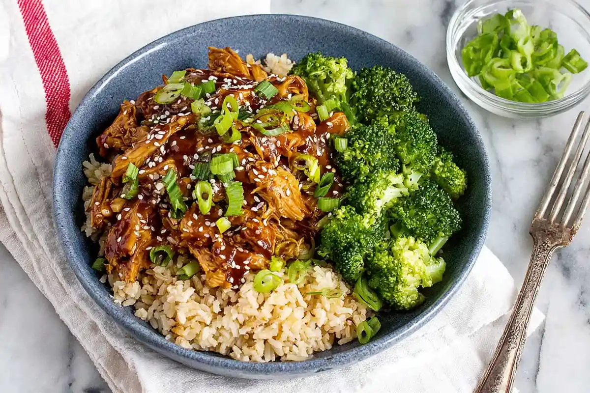 Chef Taha Ayad's Recipe Slow Cooker Honey Garlic Chicken served over rice with broccoli on a white platter