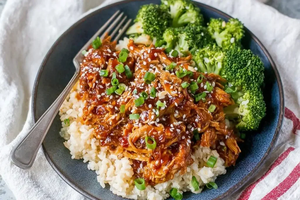 Plated Slow Cooker Honey Garlic Chicken with rice broccoli sesame seeds and green onions