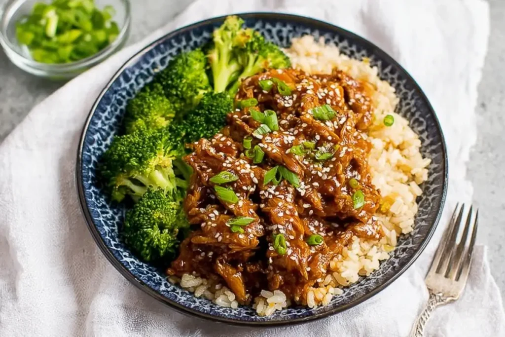 Slow Cooker Honey Garlic Chicken served with rice and broccoli on a white platter for dinner