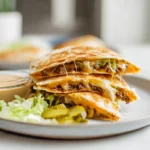 Smashburger Quesadillas served on a white plate with sauce and garnish in a modern kitchen setting
