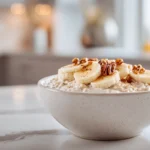 Creamy vegan cinnamon overnight oats topped with bananas, pecans, and maple syrup in a modern kitchen setting