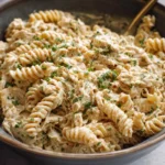 Photorealistic hero shot of crockpot garlic parmesan chicken pasta served in a modern kitchen