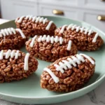 Football Rice Krispie Treats shaped like footballs on a plate