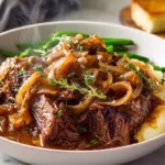 French Onion Pot Roast plated with caramelized onions and fresh herbs