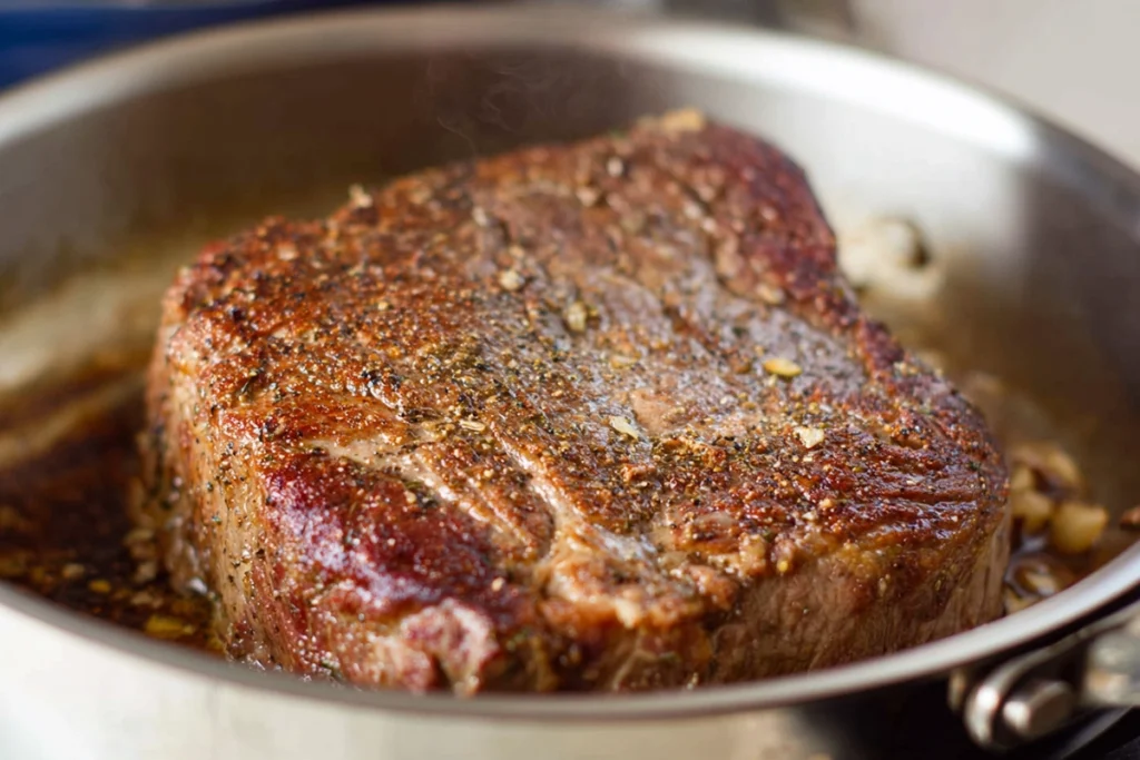 Beef chuck roast searing in pan for French Onion Pot Roast