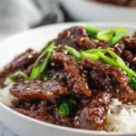 Finished Mongolian Beef served over rice on a plate in a bright home kitchen