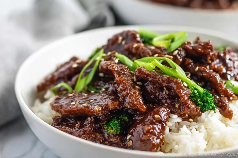 Finished Mongolian Beef served over rice on a plate in a bright home kitchen