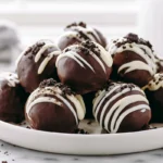 No-Bake Oreo Balls coated in chocolate on a modern plate