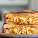 Buffalo Chicken Grilled Cheese sandwich sliced open with melted cheese and spicy chicken
