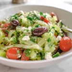 Celery Salad with fresh herbs, tomatoes, olives, and feta in a bright home kitchen