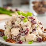 Cranberry pecan chicken salad served on a white plate in a bright home kitchen