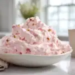 Pink Lady Salad served in a white bowl with fluffy pink texture and pecans