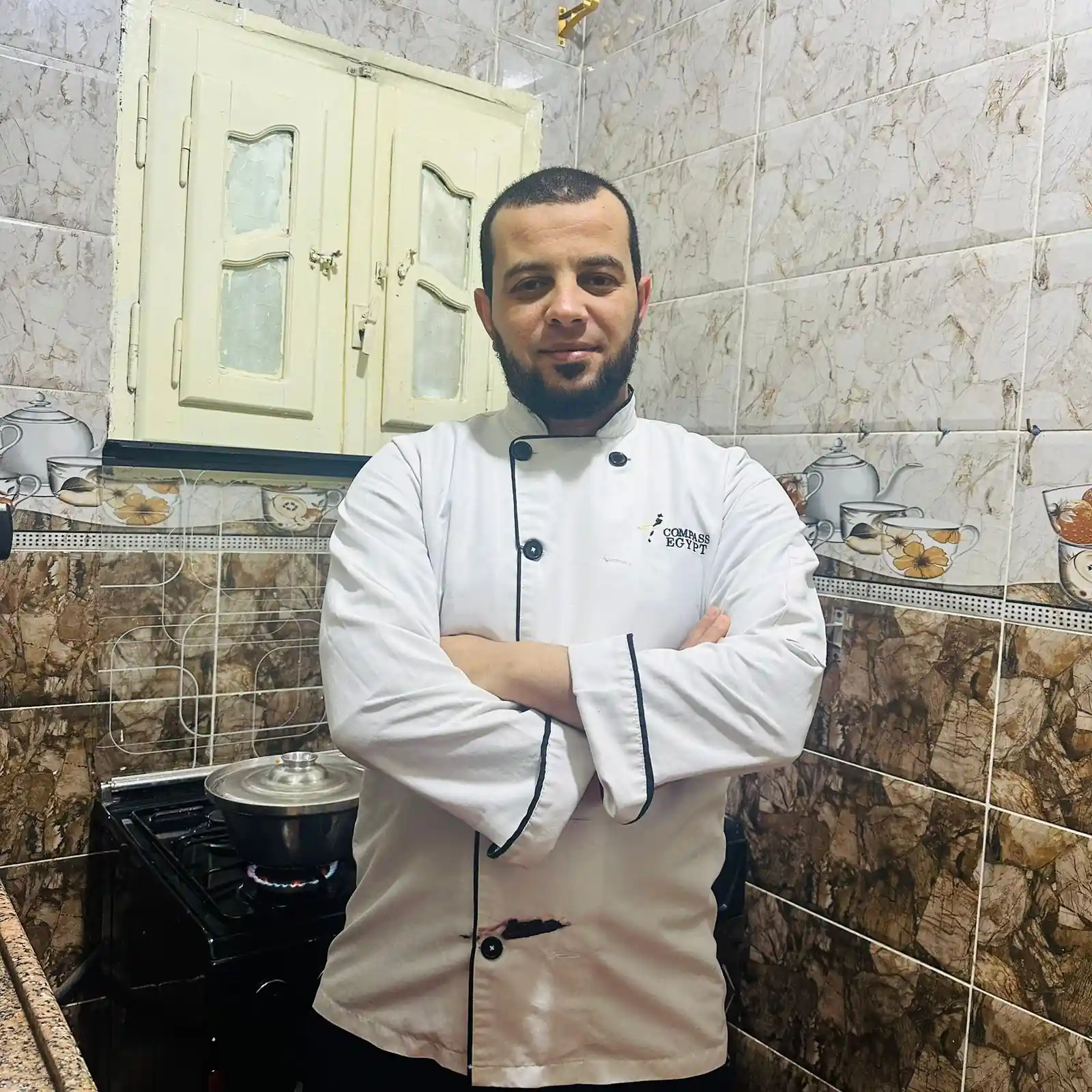 Chef Taha Ayad standing confidently in his kitchen, founder of Daily Savory Recipes
