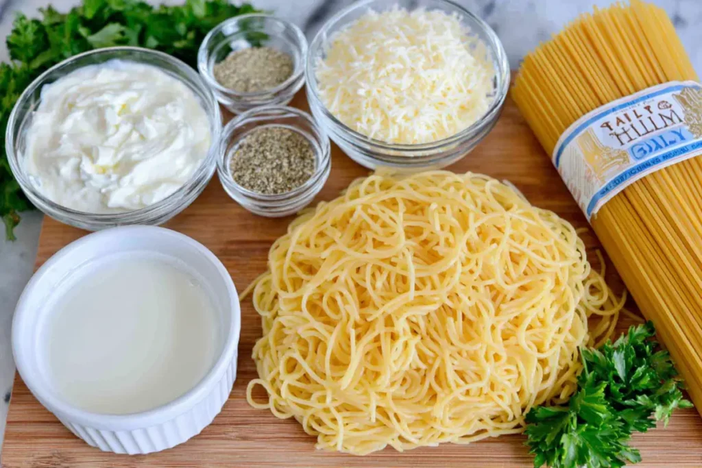 overhead view of ingredients for Creamy Garlic Pasta including spaghetti milk garlic and parmesan