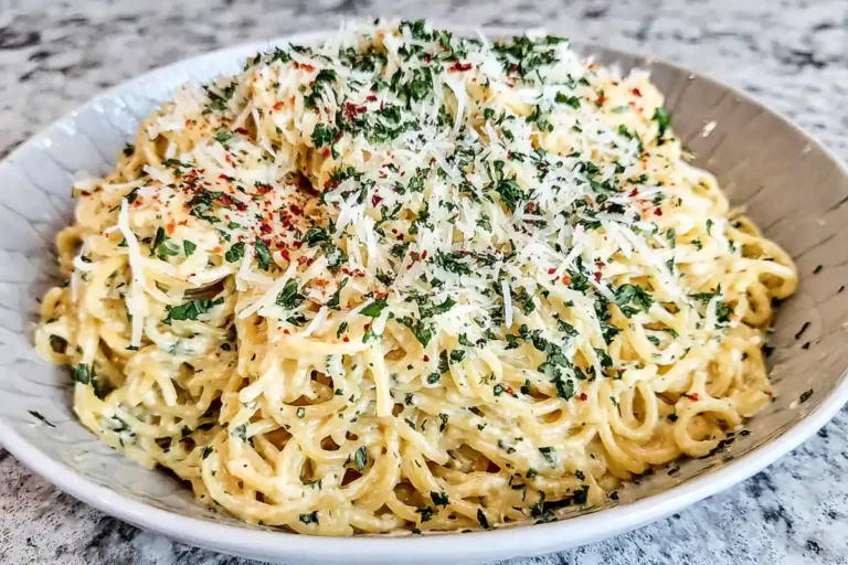 bowl of Creamy Garlic Pasta with parmesan and parsley in a bright home kitchen