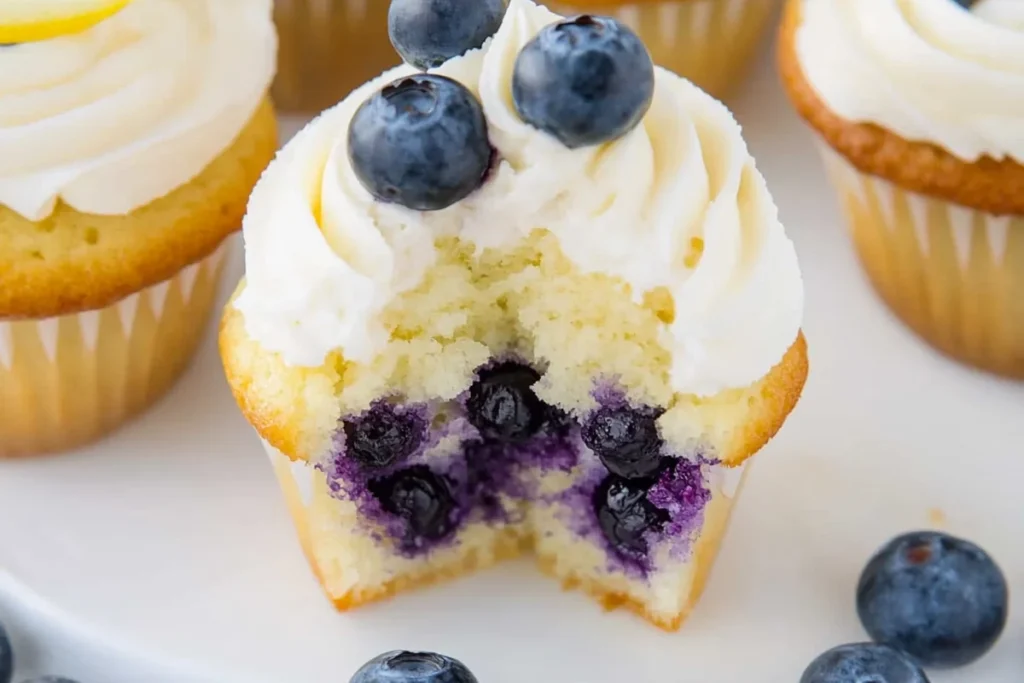 Lemon blueberry cupcakes showing soft crumb and juicy blueberries under cream cheese frosting