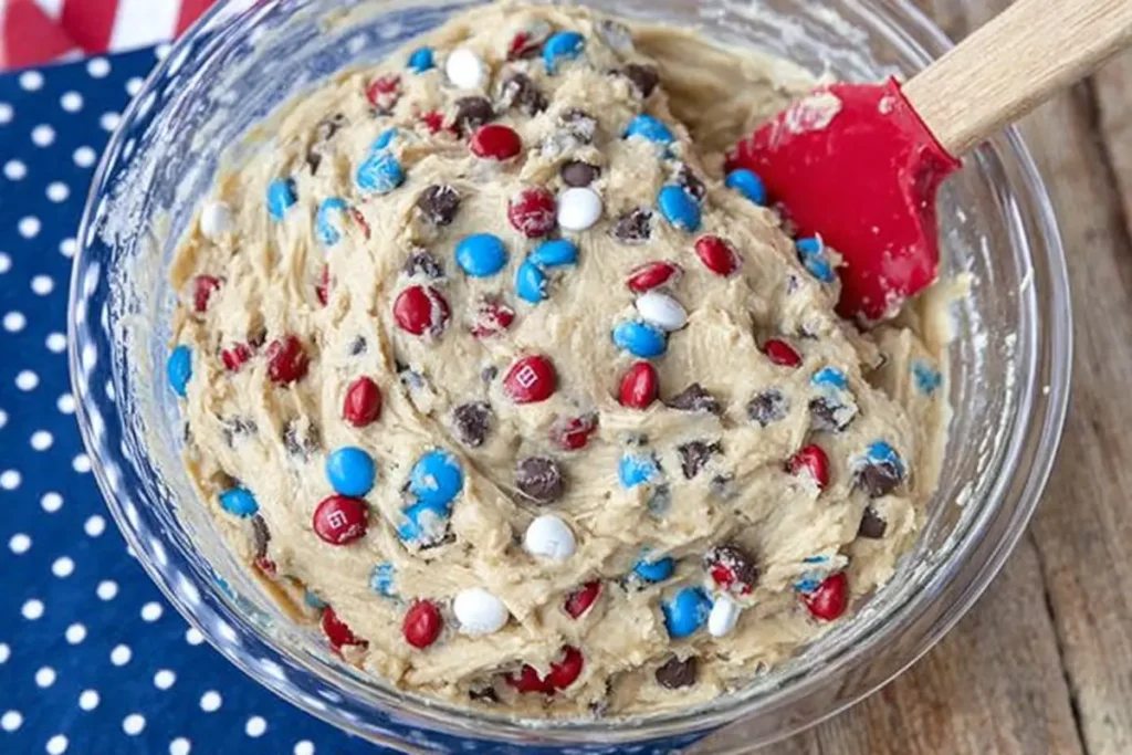 4th of July Cookie Bars That Feed a Crowd Without Fuss 8 4th of July cookie bars dough mixed with mini chocolate chips and red white and blue M&M's