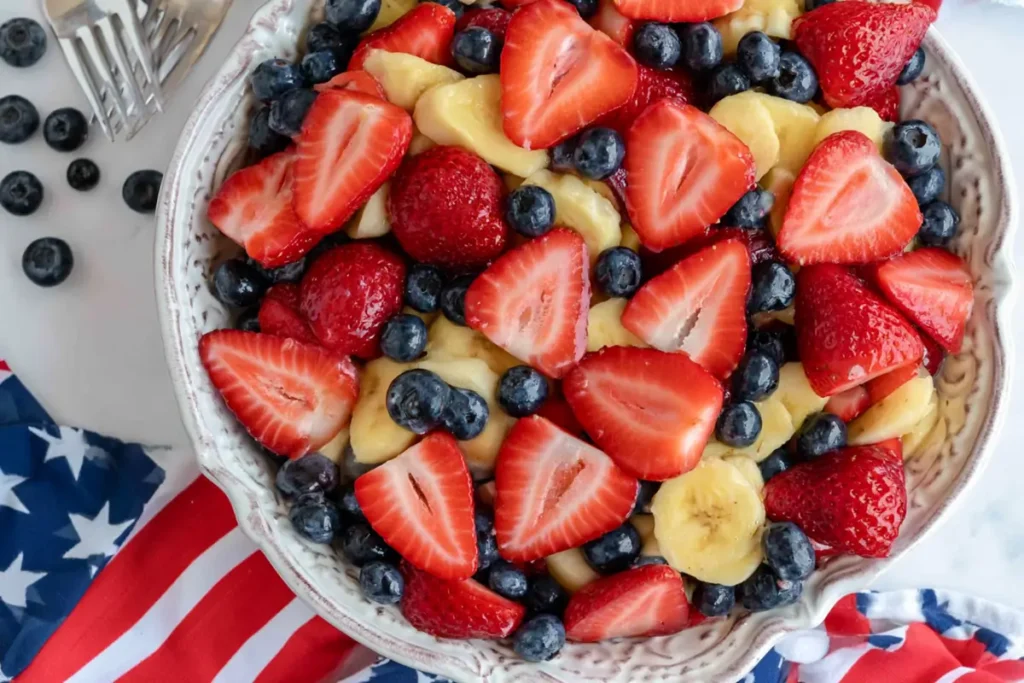 4th of July Fruit Salad With Honey Lime Dressing 15 4th of July fruit salad served in a white bowl with patriotic table decor