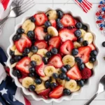 Chef Taha Ayad's Recipe 4th of July Fruit Salad With Honey Lime Dressing in a white serving bowl