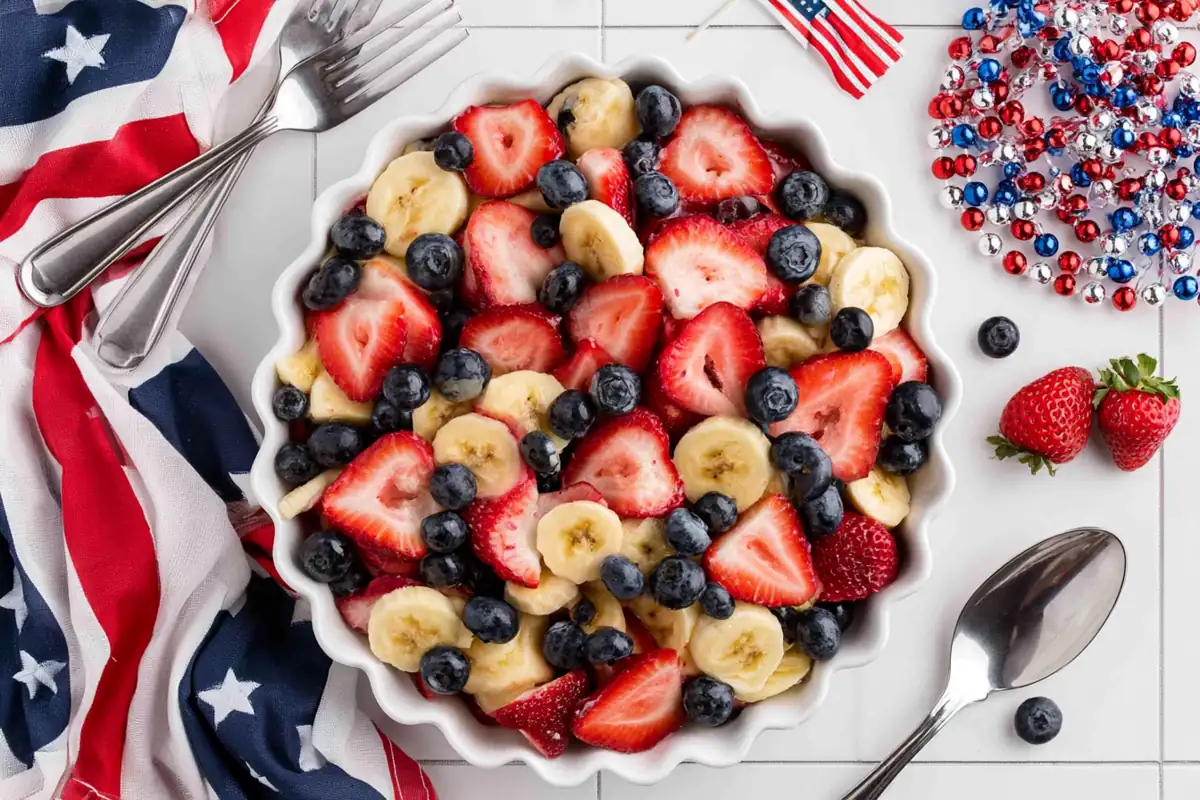 Chef Taha Ayad's Recipe 4th of July Fruit Salad With Honey Lime Dressing in a white serving bowl