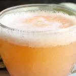 Grandma's Peach Punch recipe served as a cold slushy party drink in a glass punch bowl