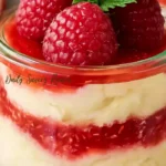 Lemon Raspberry Fluff recipe served in jars with lemon cream, smashed raspberries, and mint garnish