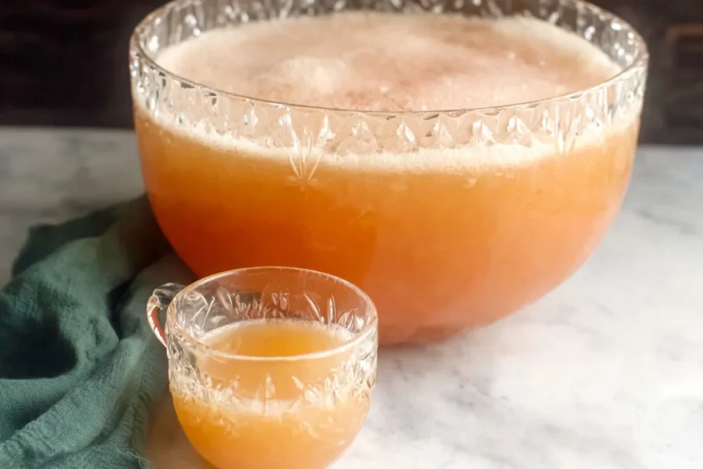 Grandma's Peach Punch for Parties, Showers, and Family Gatherings 10 Grandma's Peach Punch served in a glass punch bowl with a small cup for parties