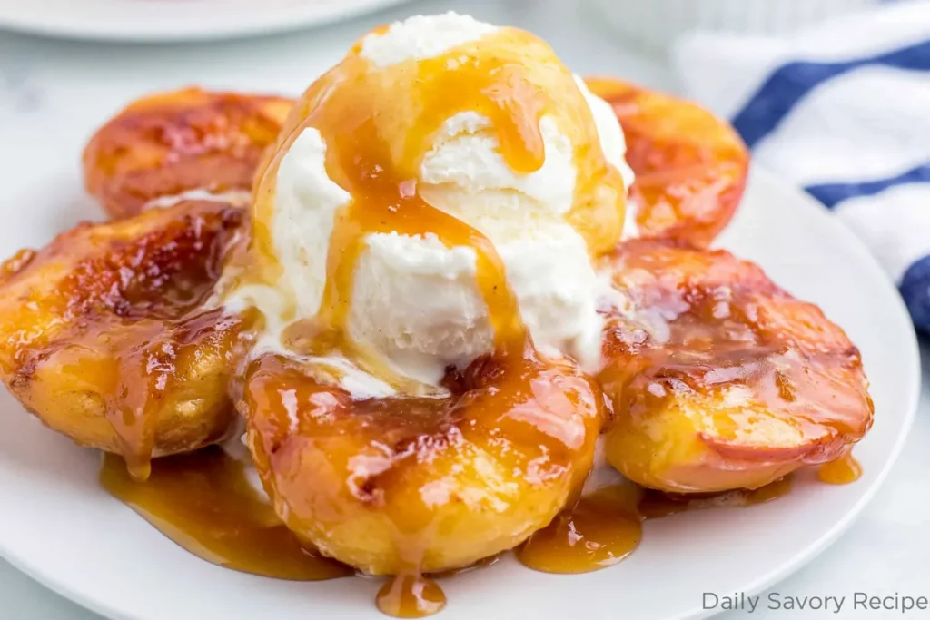 Grilled Peaches with vanilla ice cream and cinnamon butter served warm on a white plate
