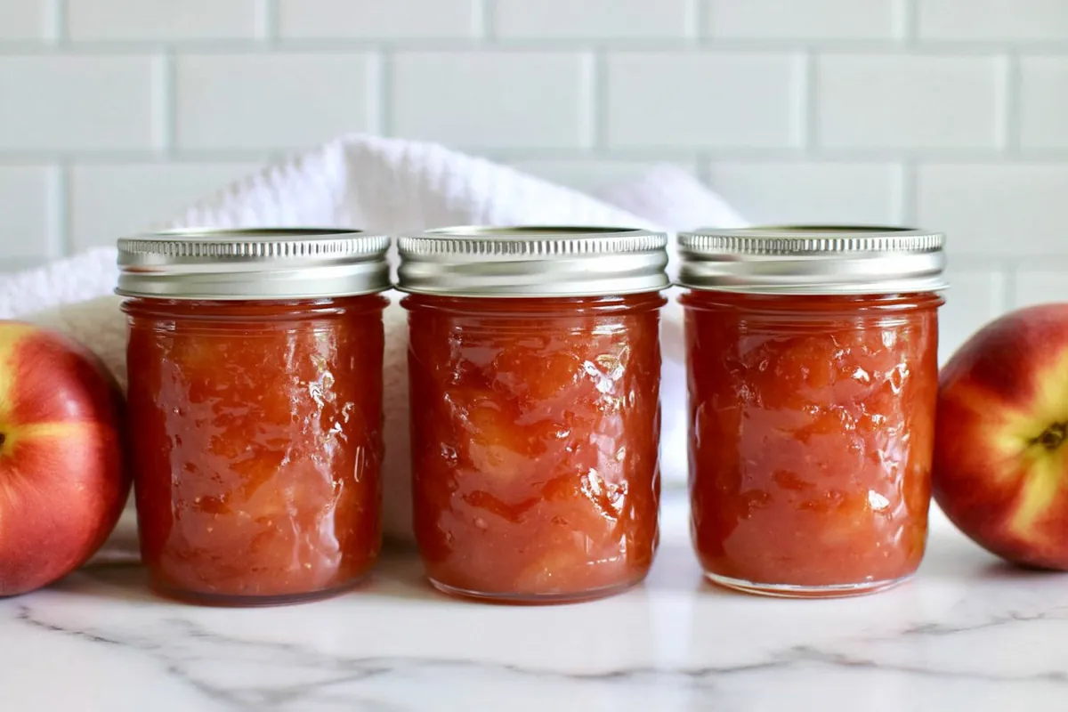 Chef Taha Ayad's Recipe Nectarine Jam with jars of homemade preserve and fresh nectarines