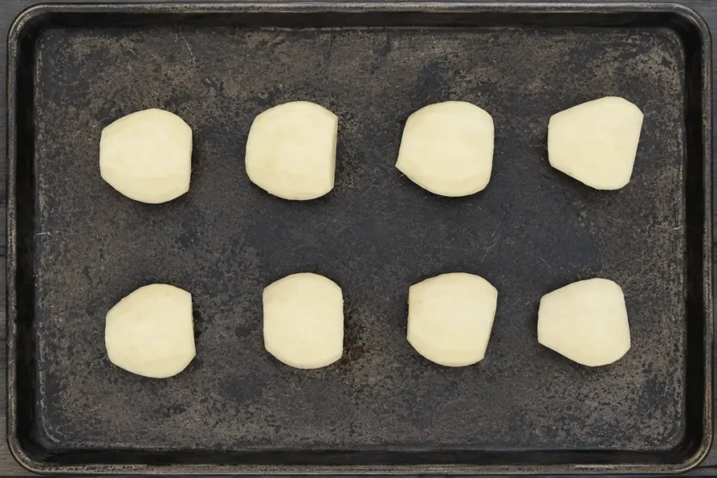 Pear halves arranged cut side down for Baked Pears on a baking sheet
