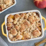 Chef Taha Ayad's Recipe Small Batch Peach Cobbler in a white ramekin with buttery crumble topping