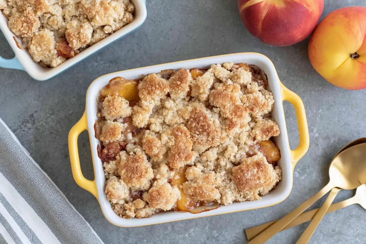 Chef Taha Ayad's Recipe Small Batch Peach Cobbler in a white ramekin with buttery crumble topping