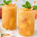 Chef Taha Ayad's Recipe Southern Peach Tea with fresh peaches, black tea, ice, and mint in tall glasses