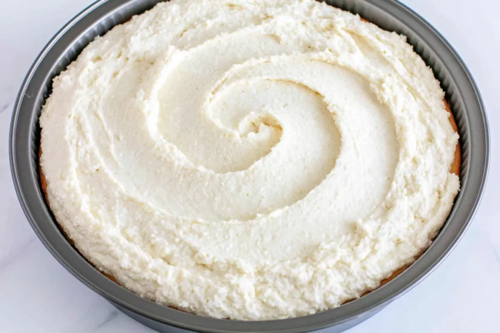 Peach Upside Down Cake batter spread evenly in a prepared round cake pan before baking
