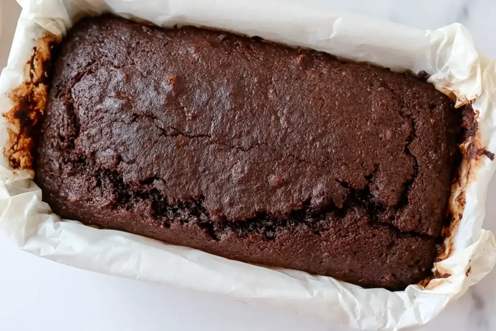 Keto Chocolate Zucchini Bread That Stays Rich and Moist 36 Baked Keto Chocolate Zucchini Bread cooling in a parchment lined loaf pan