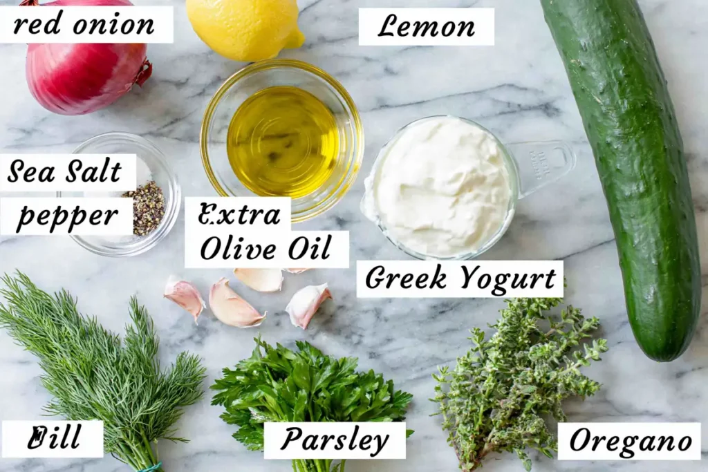 Tzatziki Cucumber Salad ingredients with cucumber, Greek yogurt, lemon, garlic, dill, parsley, oregano, and red onion