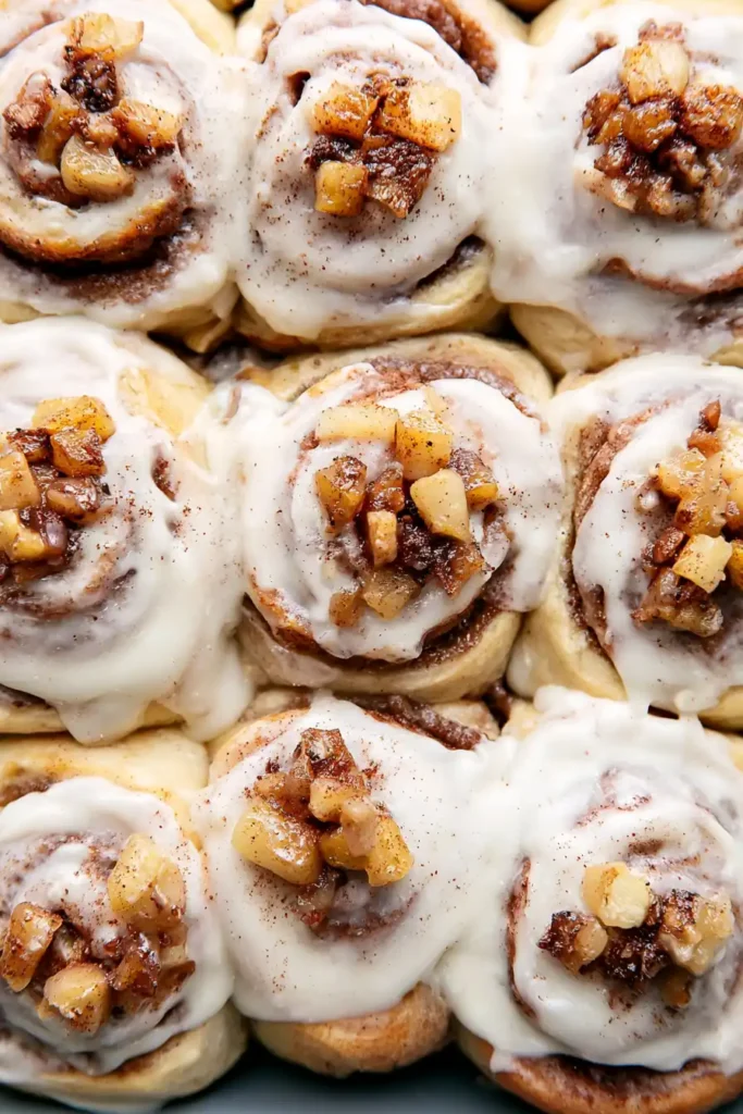 Apple Cinnamon Rolls with spiced apples and maple cream cheese frosting in a baking pan