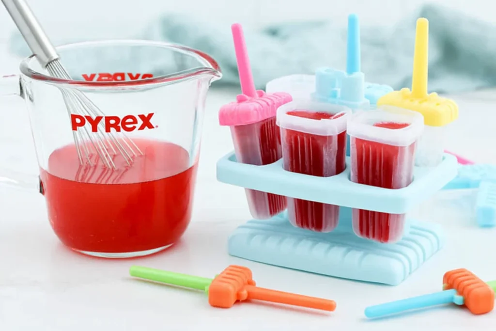 Easy Jell-O Popsicles That Hold Their Shape Longer 12 Jell-O Popsicles mixture evenly portioned into colorful freezer molds