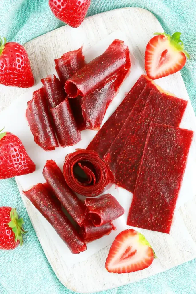 Strawberry Fruit Roll-Ups with Just 3 Simple Ingredients 7 Rolled homemade Strawberry Fruit Roll-Ups arranged for airtight storage