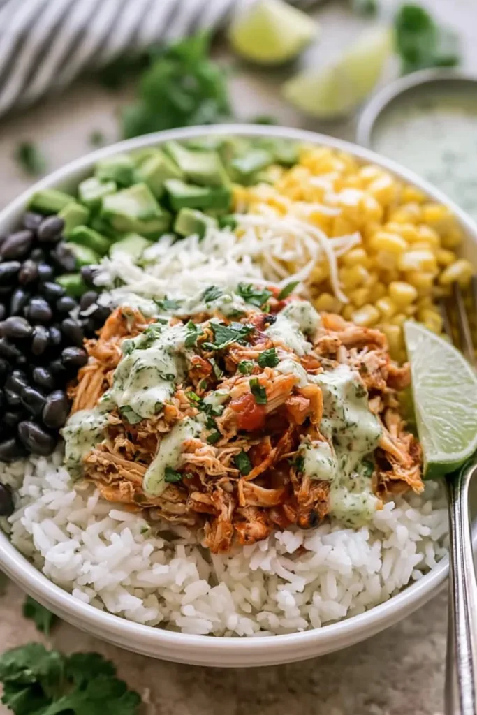 Slow Cooker Chicken Burrito Bowl for an Easy Family Dinner 6 Close-up Slow Cooker Chicken Burrito Bowl with juicy shredded chicken, rice, beans, corn, avocado, cilantro, and lime