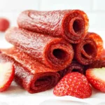 Chef Taha Ayad's Recipe Strawberry Fruit Roll-Ups stacked with fresh strawberries